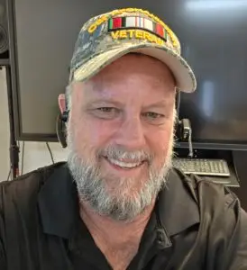 Portrait image of Patrick Bergy, founder of The Creamy Bean, in an hat, smiling and wearing two headsets