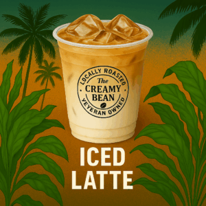 Iced Latte in a white to-go cup with The Creamy Bean logo, tropical background, available in regular and decaf