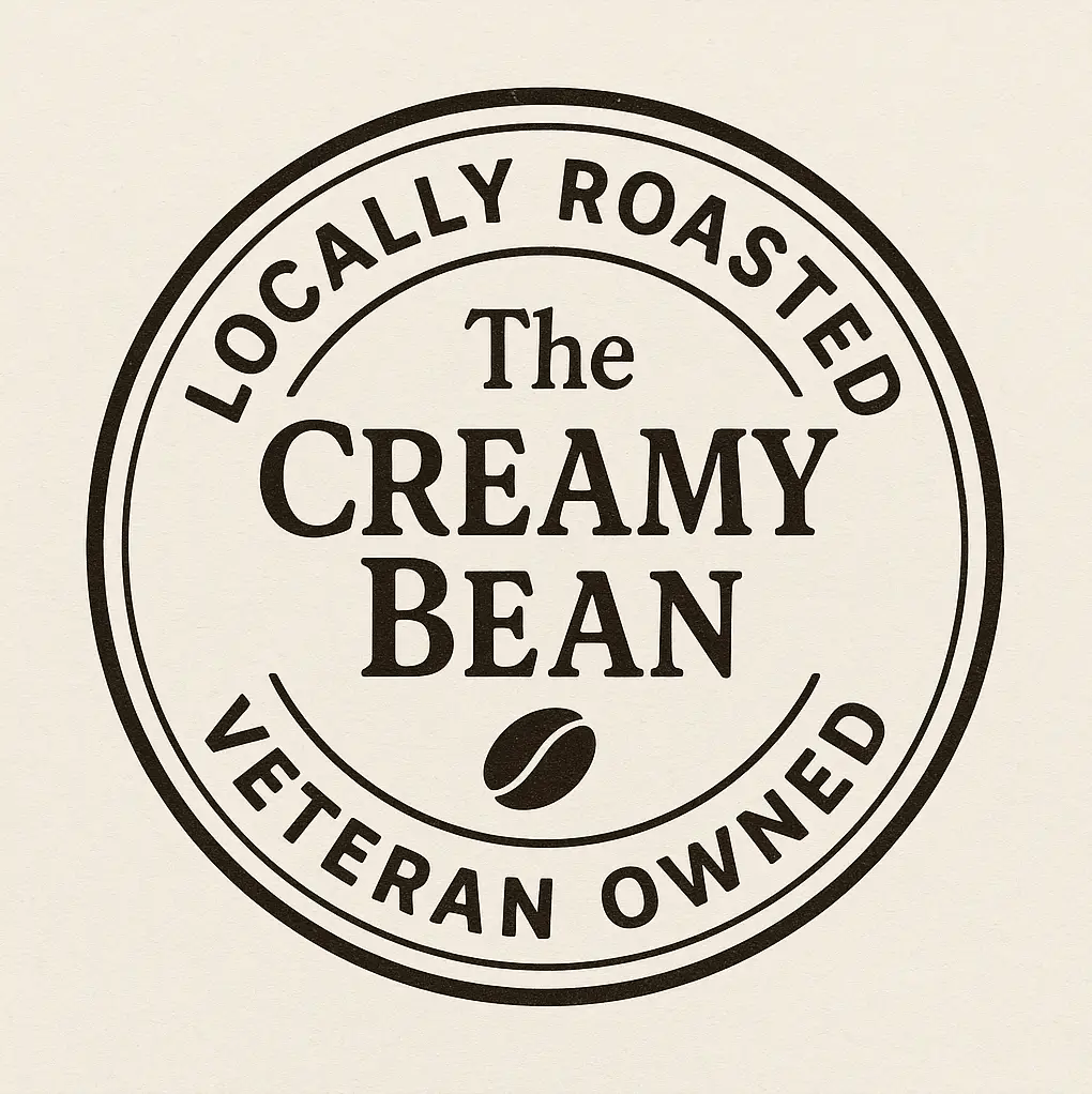 The Creamy Bean logo featuring a coffee cup with tropical design elements